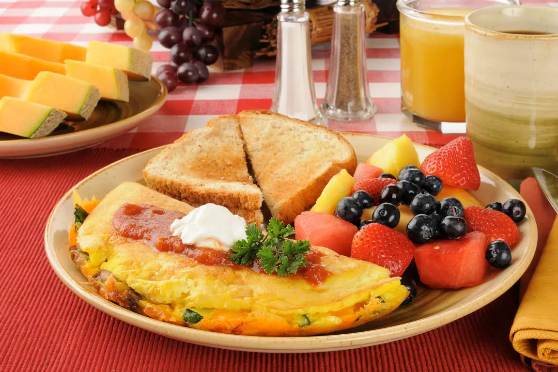 A sunlit breakfast table featuring a selection of healthy, low-calorie foods ideal for weight loss. In the foreground, a plate with a balanced meal of poached eggs, sliced avocado, and a side of fresh berries. In the middle ground, a glass of fresh-squeezed orange juice and a bowl of oatmeal topped with nuts and a drizzle of honey. The background showcases a window with lush greenery outside, creating a serene, peaceful atmosphere. The lighting is soft and natural, highlighting the vibrant colors and textures of the food. The overall scene conveys a sense of simplicity, nourishment, and a healthy start to the day.